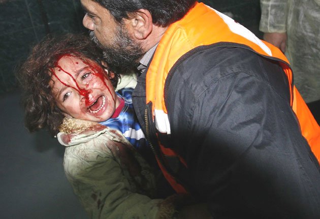 A bloodied child arrives at Shifa hospital in Gaza City after an Israeli air strike yesterday.