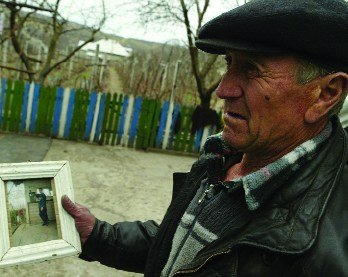 In this photograph taken March 22, 2007, Vasile Dimineti holds a picture of his 24-year-old son, who died a year after selling his kidney. The family lives in the impoverished Moldovan village of Mingir, where about 40 of its 7,000 residents are thought to have sold a kidney. AFP photo/Daniel Mihailescu/Files