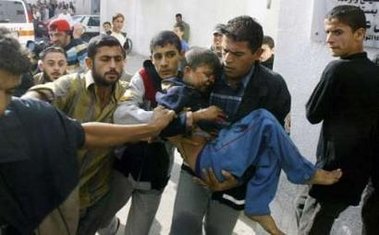 A Palestinian man carries a wounded boy.