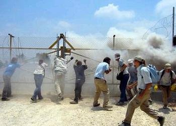 Demonstrators protesting Israel’s construction of a separation barrier through Palestinian land are tear gassed.